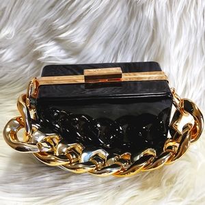Aldo clutch in black and gold metal detailing.